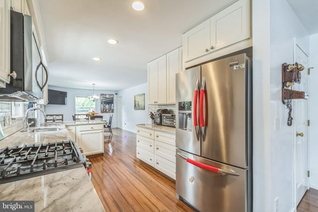 1622 Amosland Rd, Prospect Park, PA 19076 - kitchen with stainless steel appliances, light wood finished floors, tasteful backsplash, recessed lighting, and white cabinetry