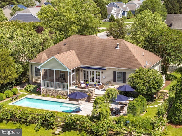 112 W Shore Dr, Milton, DE 19968 - back of house with a sunroom, an outdoor hangout area, a patio area, an outdoor pool, and roof with shingles
