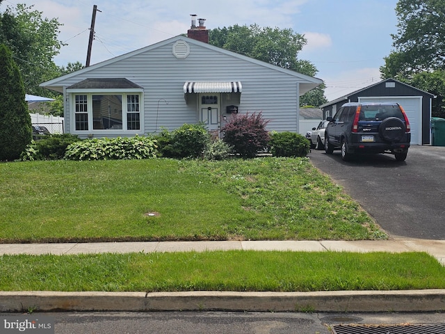 72 Basswood Rd, Levittown, PA 19057 - view of front of home featuring a front yard, a chimney, and asphalt driveway
