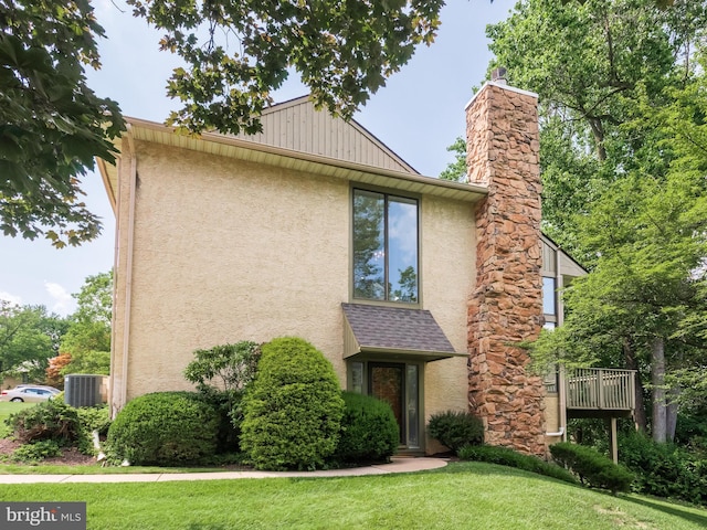 398 Lynetree Dr Unit 11-D, West Chester, PA 19380 - view of front of property featuring stucco siding, a chimney, and a front yard