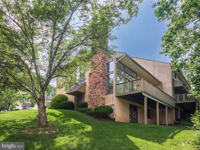 398 Lynetree Dr Unit 11-D, West Chester, PA 19380 - rear view of property featuring stucco siding, a yard, and a wooden deck