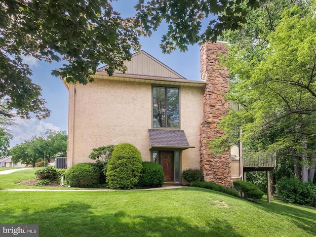 398 Lynetree Dr Unit 11-D, West Chester, PA 19380 - view of front of home featuring stucco siding, a front yard, and a chimney