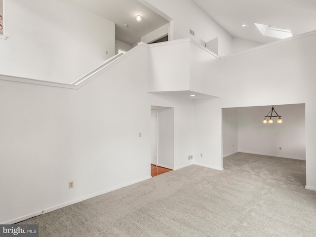 398 Lynetree Dr Unit 11-D, West Chester, PA 19380 - unfurnished living room with carpet floors, a skylight, and high vaulted ceiling