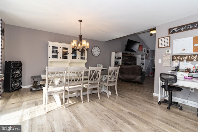 5 N Edinburgh Ct, Houston, DE 19954 - dining space featuring ceiling fan, wood finished floors, a chandelier, a fireplace, and an office area