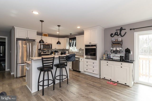 5 N Edinburgh Ct, Houston, DE 19954 - kitchen featuring stainless steel appliances, backsplash, white cabinets, a kitchen breakfast bar, and recessed lighting