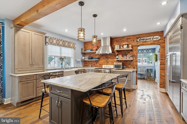 130 E State St, Media, PA 19063 - kitchen with wall chimney range hood, open shelves, a kitchen breakfast bar, light countertops, and dark wood-style flooring