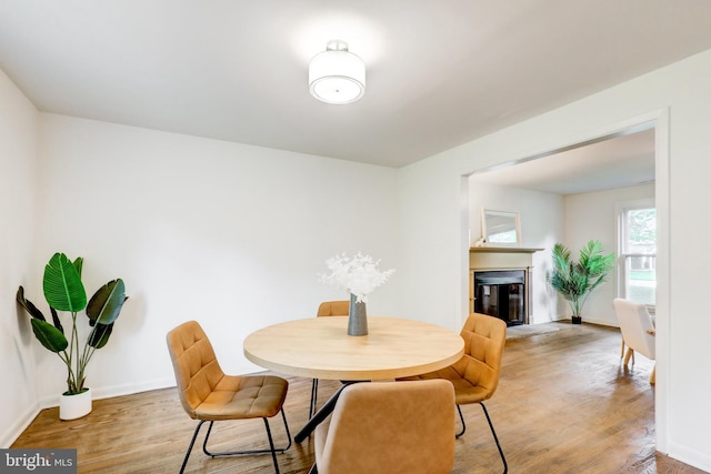 406 Christian Ln, Wallingford, PA 19086 - dining area with light wood-style floors and a glass covered fireplace