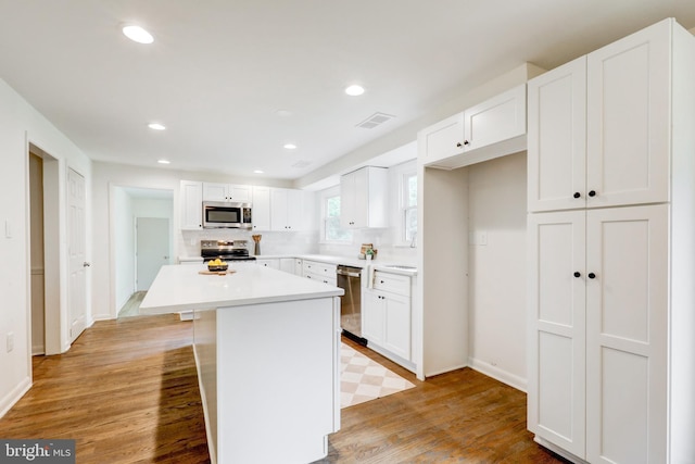 406 Christian Ln, Wallingford, PA 19086 - kitchen with stainless steel appliances, white cabinets, light wood-type flooring, a center island, and recessed lighting