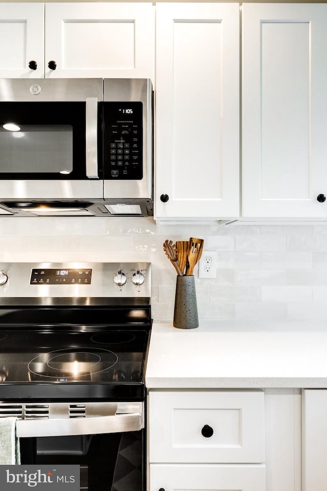 406 Christian Ln, Wallingford, PA 19086 - kitchen featuring stainless steel appliances, white cabinetry, backsplash, and light countertops