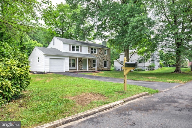 406 Christian Ln, Wallingford, PA 19086 - traditional-style house with covered porch, a chimney, a front yard, an attached garage, and stone siding