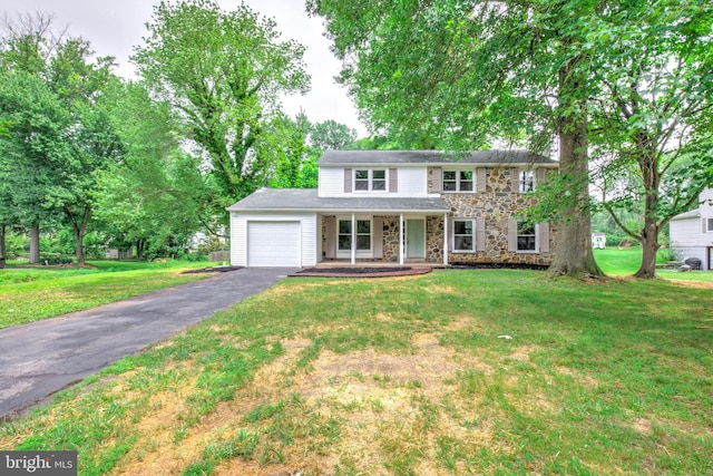 406 Christian Ln, Wallingford, PA 19086 - traditional-style home with an attached garage, asphalt driveway, stone siding, covered porch, and a front yard