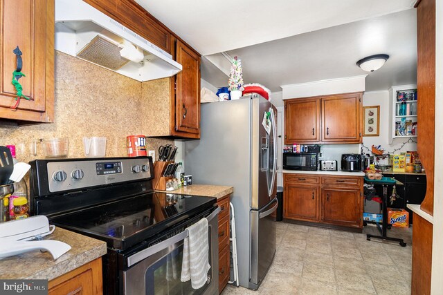 313 E Main St, Mechanicsburg, PA 17055 - kitchen featuring appliances with stainless steel finishes, under cabinet range hood, brown cabinetry, and light countertops
