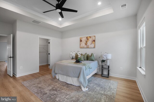 8109 Primrose Ln, Laurel, MD 20723 - bedroom with a raised ceiling, light wood finished floors, a walk in closet, recessed lighting, and ceiling fan