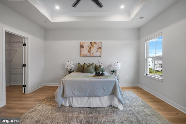8109 Primrose Ln, Laurel, MD 20723 - bedroom with a tray ceiling, wood finished floors, a spacious closet, recessed lighting, and ornamental molding