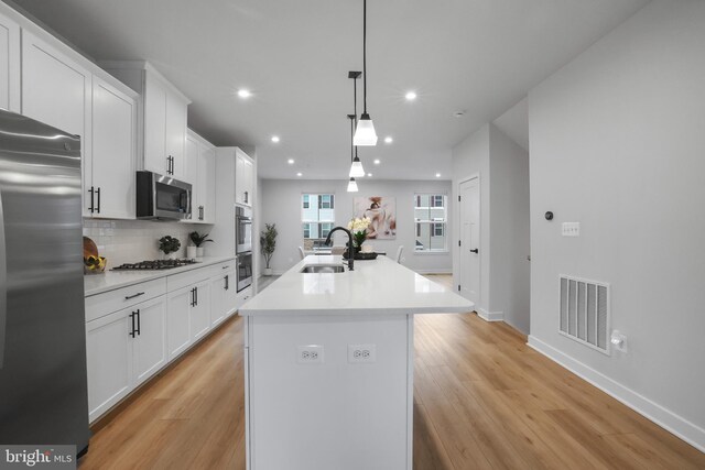 8109 Primrose Ln, Laurel, MD 20723 - kitchen featuring stainless steel appliances, a kitchen island with sink, light wood-style flooring, recessed lighting, and white cabinetry