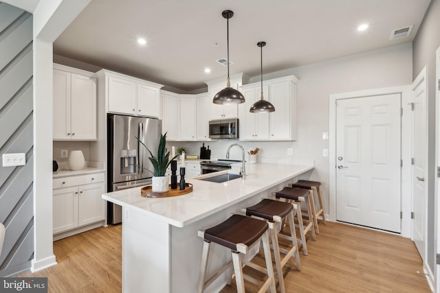 2017 Abboccato Ter SE, Leesburg, VA 20175 - kitchen featuring stainless steel appliances, a kitchen breakfast bar, light wood finished floors, a peninsula, and white cabinetry