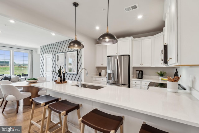2017 Abboccato Ter SE, Leesburg, VA 20175 - kitchen with stainless steel appliances, light countertops, a peninsula, white cabinetry, and a kitchen bar