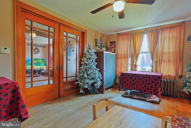 439 Columbia St, Cumberland, MD 21502 - entrance foyer with radiator, a textured ceiling, wood finished floors, a ceiling fan, and french doors