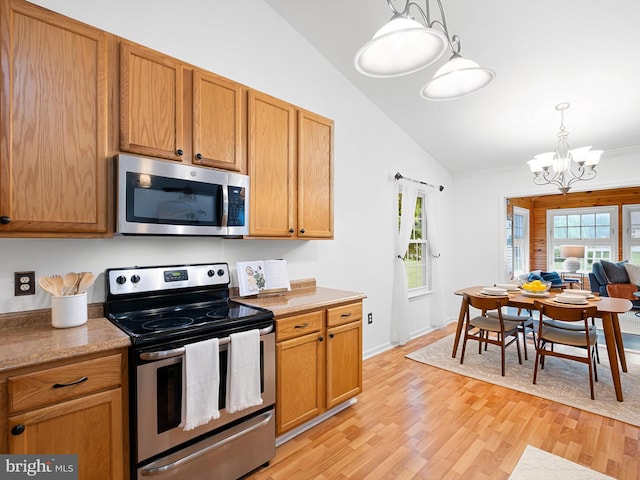 207 Drawyers Dr, Middletown, DE 19709 - kitchen featuring stainless steel appliances, vaulted ceiling, a chandelier, light wood finished floors, and hanging light fixtures