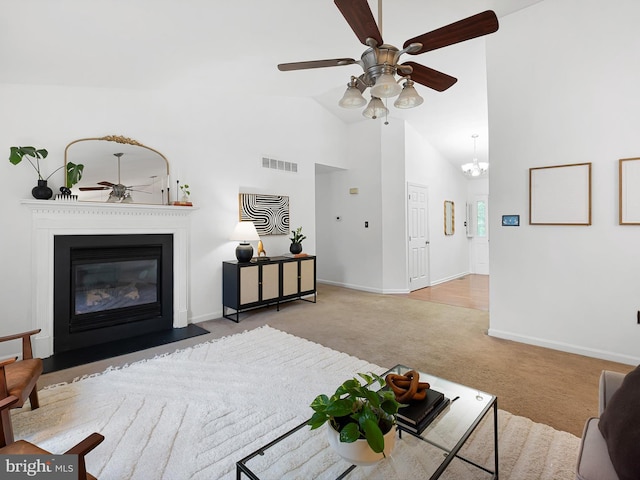 207 Drawyers Dr, Middletown, DE 19709 - carpeted living room featuring ceiling fan, a fireplace with flush hearth, high vaulted ceiling, and a chandelier