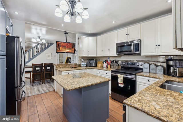 5509 Chew Ave, Philadelphia, PA 19138 - kitchen with appliances with stainless steel finishes, a chandelier, a peninsula, recessed lighting, and white cabinetry