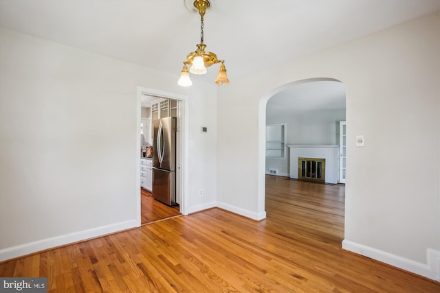 5909 Frederick St, Springfield, VA 22150 - unfurnished room featuring arched walkways, light wood finished floors, and a fireplace