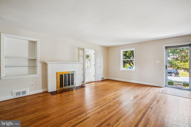 5909 Frederick St, Springfield, VA 22150 - unfurnished living room with plenty of natural light, wood finished floors, and a brick fireplace