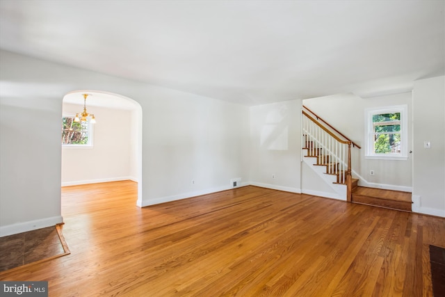 5909 Frederick St, Springfield, VA 22150 - unfurnished living room with arched walkways, plenty of natural light, stairway, and light wood-type flooring