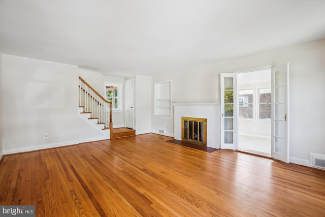 5909 Frederick St, Springfield, VA 22150 - unfurnished living room featuring plenty of natural light, stairway, wood finished floors, and a brick fireplace
