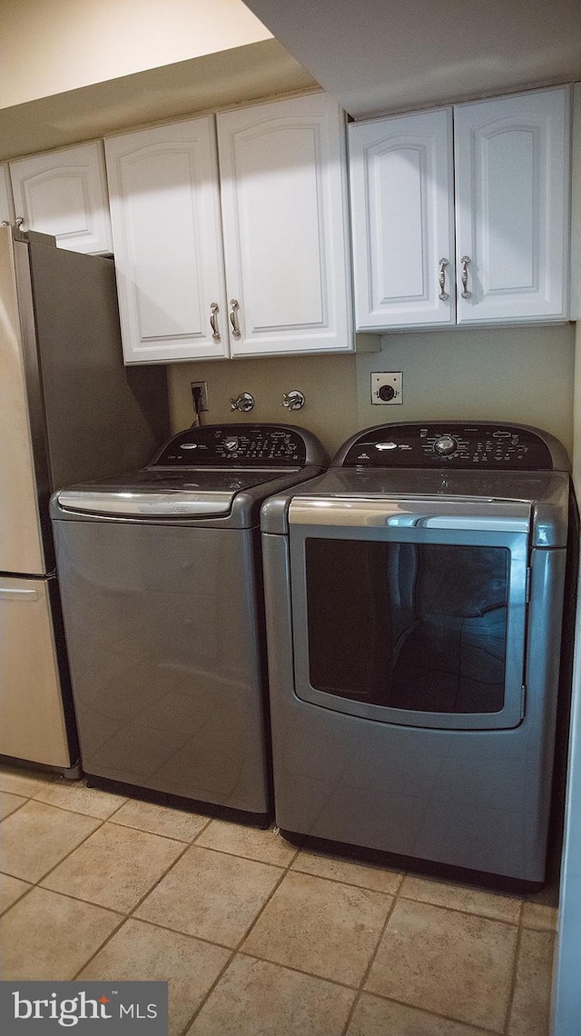 16 Stonehenge Cir Unit 16-5, Baltimore, MD 21208 - laundry room featuring washing machine and clothes dryer, cabinet space, and light tile patterned flooring