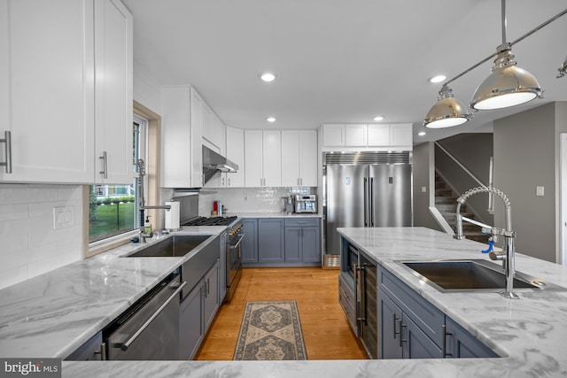 1 Risner Ave, Penns Grove, NJ 08069 - kitchen featuring high quality appliances, white cabinetry, light wood finished floors, light stone counters, and under cabinet range hood
