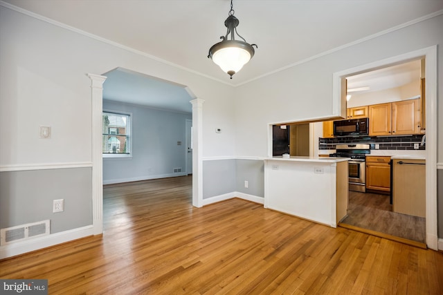 2013 Dayton St, Silver Spring, MD 20902 - kitchen featuring black microwave, ornate columns, stainless steel range with gas cooktop, light wood-style flooring, and ornamental molding