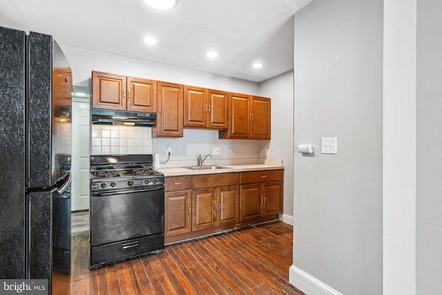 2006 N Mascher St, Philadelphia, PA 19122 - kitchen featuring black appliances, under cabinet range hood, dark wood-style flooring, brown cabinetry, and light countertops