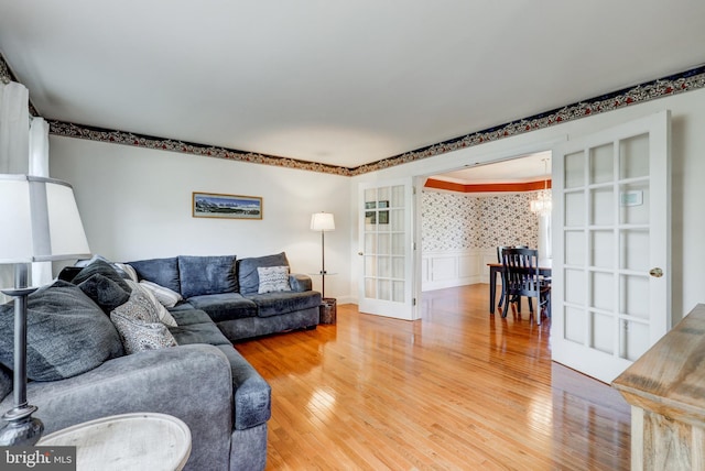 2912 Weaver Rd, Lancaster, PA 17601 - living area featuring light wood finished floors, a wainscoted wall, a chandelier, and french doors