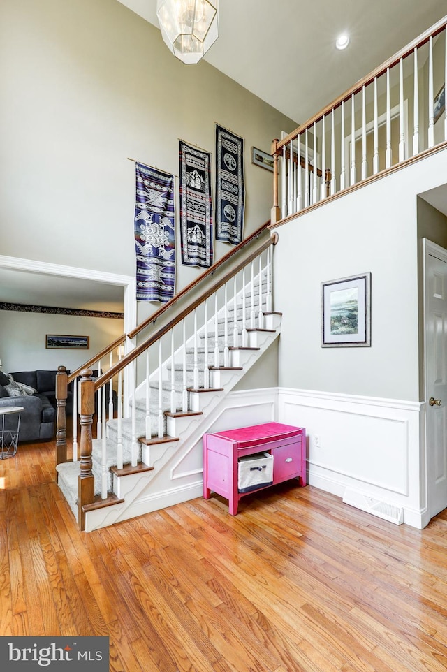 2912 Weaver Rd, Lancaster, PA 17601 - stairs featuring wood finished floors, a towering ceiling, wainscoting, and a decorative wall