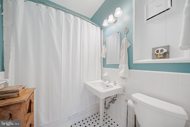 2737 Devonshire Pl NW Unit 321, Washington, DC 20008 - bathroom with a shower with curtain, tile walls, and a wainscoted wall