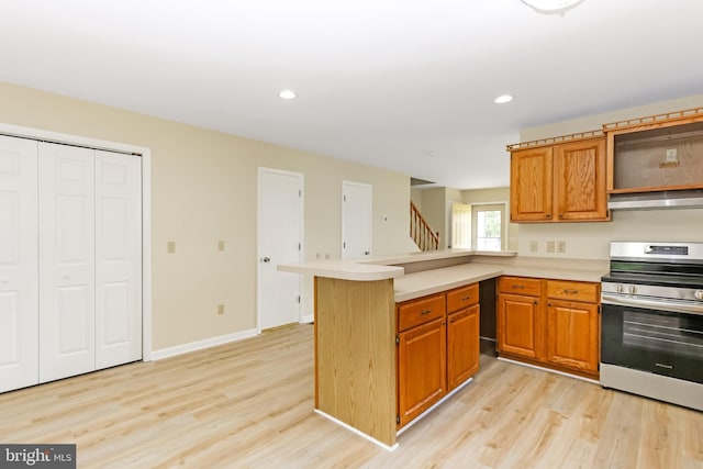 4421 Eastwinds, Chincoteague Island, VA 23336 - kitchen featuring stainless steel electric stove, light wood-style flooring, under cabinet range hood, light countertops, and recessed lighting