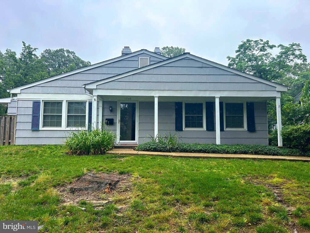 1746 Woodridge Ct, Crofton, MD 21114 - view of front of house with a front yard, a chimney, and a porch