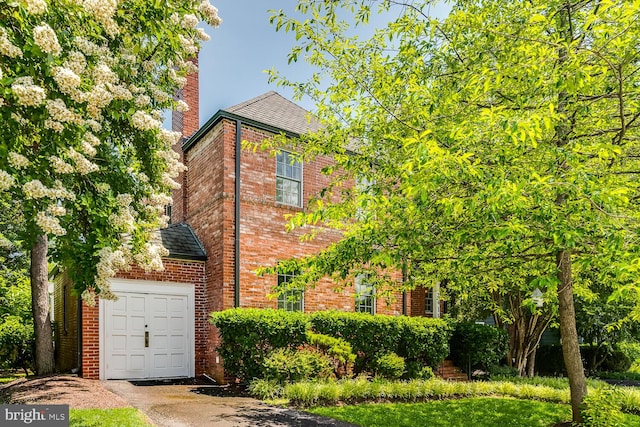 2413 Taylor Ave, Alexandria, VA 22302 - view of front of home featuring brick siding, a chimney, an attached garage, and asphalt driveway