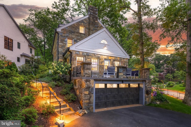 3666 Military Rd, Arlington, VA 22207 - view of front of home featuring stone siding, a balcony, a garage, and a chimney