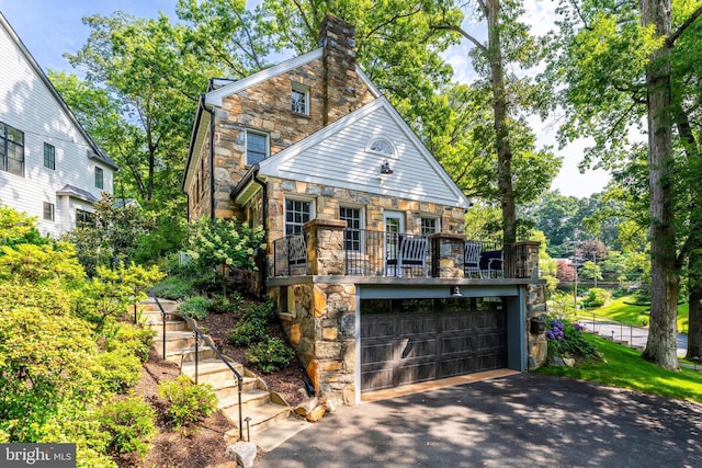 3666 Military Rd, Arlington, VA 22207 - view of front of house with stone siding, driveway, an attached garage, and a balcony
