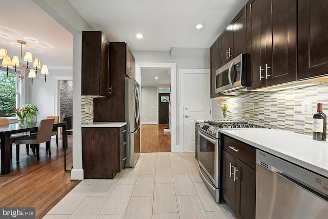 3831 Fulton St NW, Washington, DC 20007 - kitchen with appliances with stainless steel finishes, a chandelier, light countertops, dark brown cabinetry, and recessed lighting