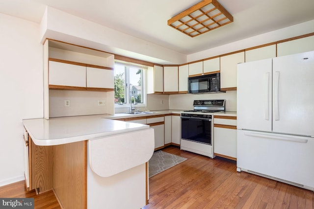 2381 Greensward S, Warrington, PA 18976 - kitchen featuring freestanding refrigerator, black microwave, range with gas stovetop, a peninsula, and light countertops