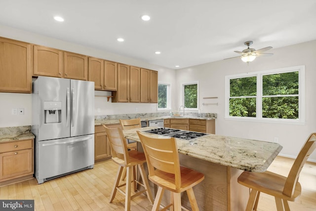 12177 Flowing Water Trl, Clarksville, MD 21029 - kitchen featuring appliances with stainless steel finishes, light wood-style floors, ceiling fan, recessed lighting, and a kitchen breakfast bar