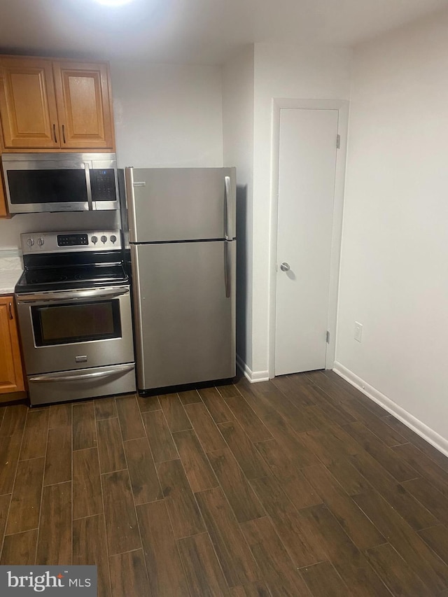 11393 Laurelwalk Dr Unit B-141, Laurel, MD 20708 - kitchen with stainless steel appliances, dark wood-style flooring, light countertops, and brown cabinetry