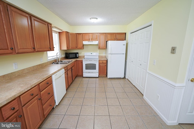 120 Ridgefield Ln, Fruitland, MD 21826 - kitchen featuring white appliances, under cabinet range hood, brown cabinetry, wainscoting, and a textured ceiling