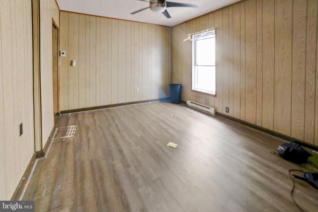 319 1st St, Slatington, PA 18080 - empty room with a baseboard heating unit, a ceiling fan, wood finished floors, and wooden walls