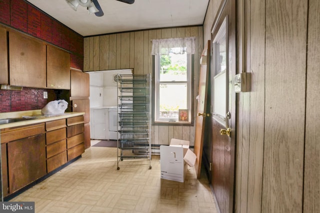 319 1st St, Slatington, PA 18080 - kitchen featuring a ceiling fan, wood walls, light countertops, washer / dryer, and backsplash