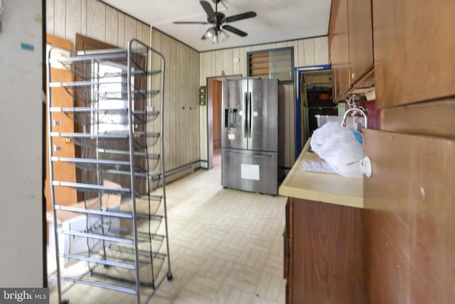 319 1st St, Slatington, PA 18080 - kitchen with stainless steel fridge with ice dispenser, a ceiling fan, and wood walls