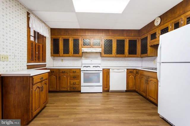 31 4th St, Hanover, PA 17331 - kitchen featuring white appliances, under cabinet range hood, light countertops, light wood-style flooring, and brown cabinets